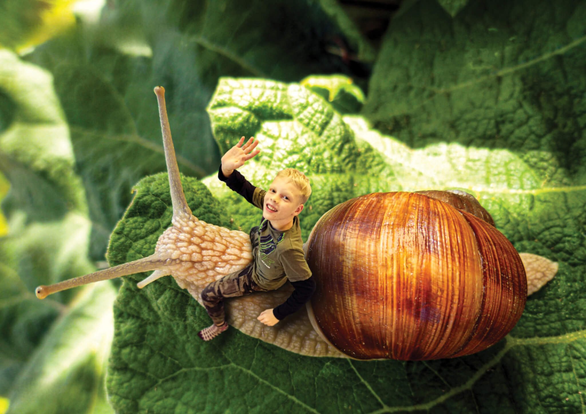 Un enfant assis sur un escargot géant dans la galerie LaborARTorium